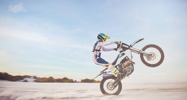Motorbike, motorcycle athlete and desert drive with mockup cycling in nature for sport adventure. Jump, freedom and sports driving training of a man with speed on sand trail for fitness and exercise. - 写真・画像