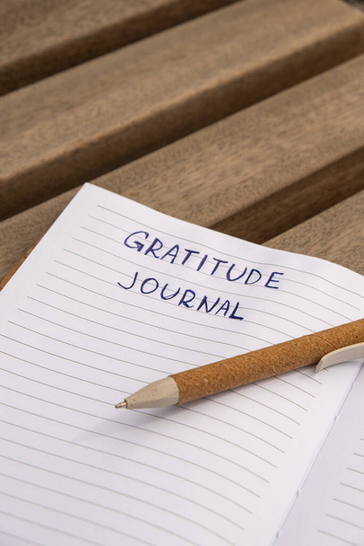 Пишу "Gratitude Journal" на деревянной скамейке. Сегодня я благодарен за это. Журнал самопознания, саморефлексия, творческое письмо, концепция личностного развития. Самочувствие духовное здоровье, внимательность, целостное здоровье хаб - Фото, изображение