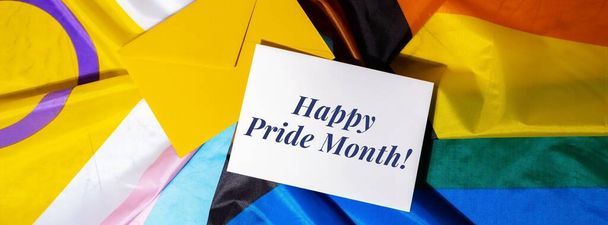 HAPPY PRIDE MONTH text on postcard inscription positive quote phrase Greeting card on Rainbow LGBTQIA flag made from silk material. Symbol of LGBTQ pride month. Equal rights. Peace and freedom. Support LGBTQIA community. Diversity equality - Fotoğraf, Görsel