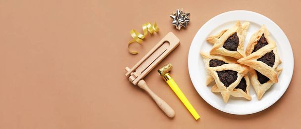 Hamantaschen cookies and noisemakers for Purim holiday on brown background with space for text - Φωτογραφία, εικόνα