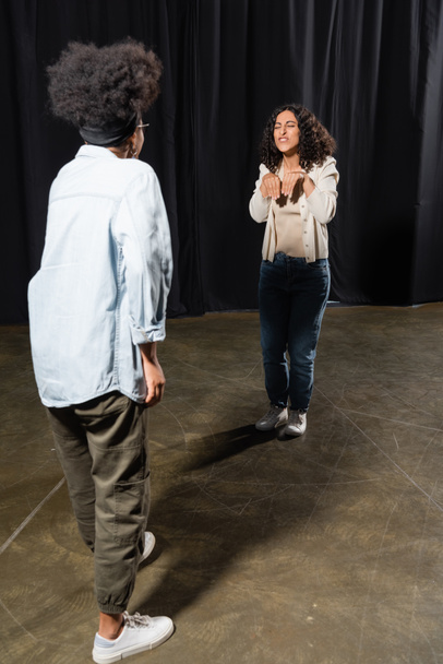 multiracial woman rehearsing near african american woman on blurred foreground - Photo, image