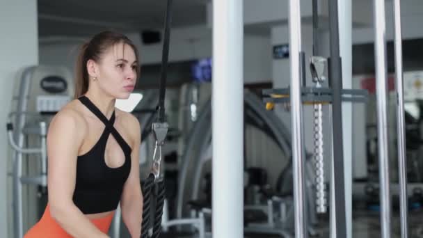 A young sporty girl is training her arm muscles, she is doing triceps exercise in the gym. Healthy Lifestyle - Filmmaterial, Video