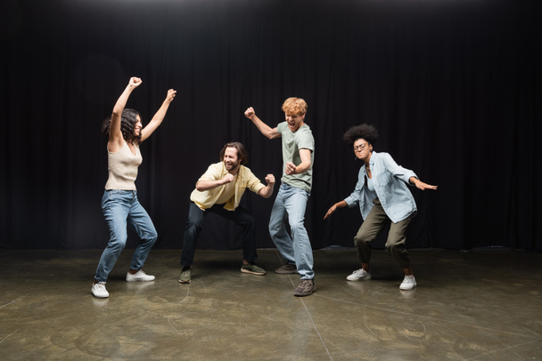 full length of excited interracial students posing in acting skills studio - Photo, Image