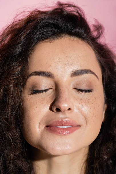 Portrait of smiling freckled woman closed eyes isolated on pink  - Fotografie, Obrázek