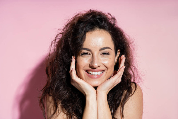 Happy freckled woman looking at camera on pink background  - Φωτογραφία, εικόνα