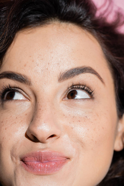 Close up view of pleased and freckled woman looking up  - Foto, Imagem