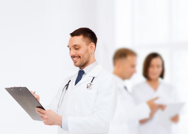 lachende mannelijke arts met Klembord en stethoscoop - Foto, afbeelding