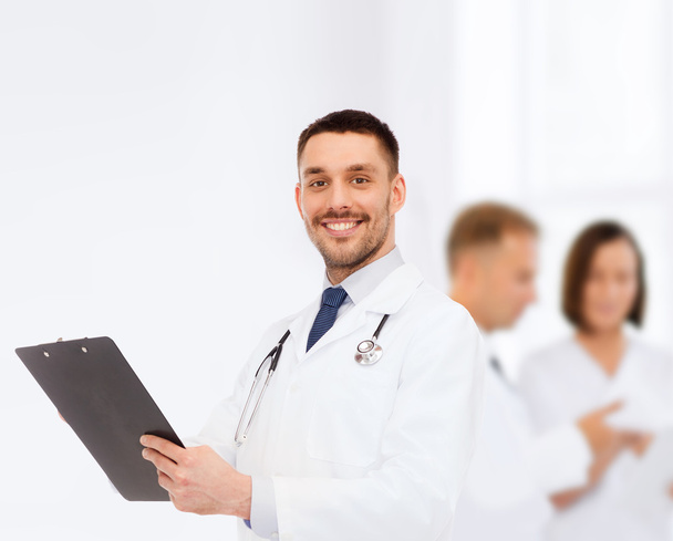smiling male doctor with clipboard and stethoscope - Foto, afbeelding