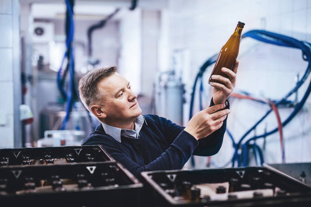 Man preparing craft beer from brewery for shipment. Middle-aged man with expertise - Foto, imagen