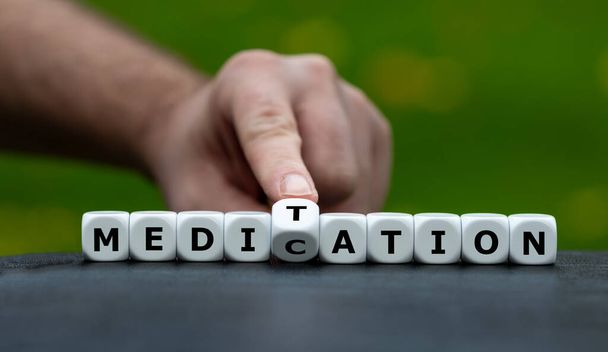 Symbol for doing meditation instead of taking medication. Hand turns dice and changes the word medication to meditation. - Foto, Bild