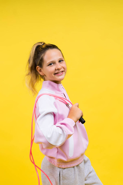 Adorable female child with skipping rope jumping in a studio - Foto, Imagen