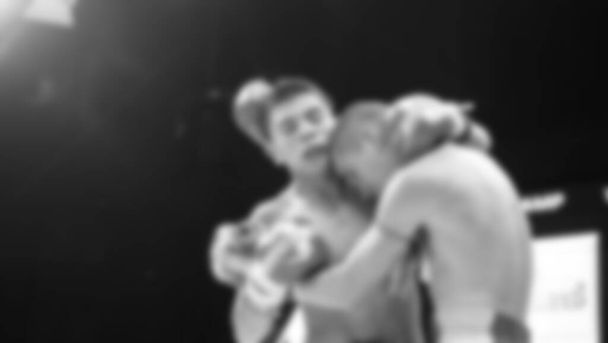 Blurred images black and white photo style of Thai boxing or Muay Thai or Kickboxing which local and foriegn boxer are fighting on the ring at indoor stage as martial art sport. Muay Thai Kick boxing - Φωτογραφία, εικόνα