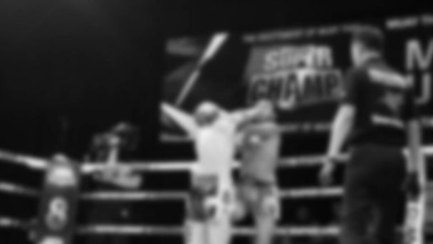 Blurred images black and white photo style of Thai boxing or Muay Thai or Kickboxing which local and foriegn boxer are fighting on the ring at indoor stage as martial art sport. Muay Thai Kick boxing - Foto, Imagen