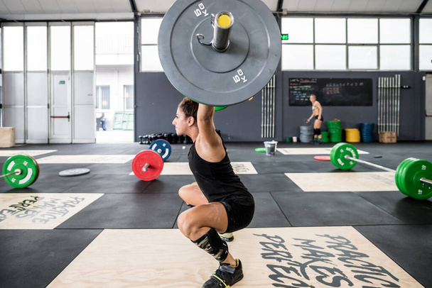 Athletic woman exercising deadlift in a gym using barbell power lifting - Φωτογραφία, εικόνα