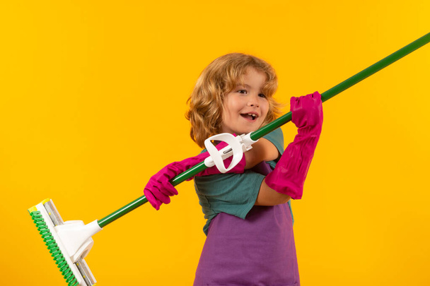 Limpieza de casa. Estudio retrato aislado de la casa de fregar niño, limpieza de la casa. Detergentes y accesorios de limpieza. Servicio de limpieza. Pequeño chico divertido ama de llaves - Foto, imagen