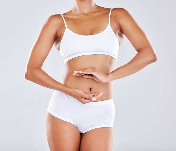 Wellness, gut health and hands on stomach of woman in studio for nutrition, healthy eating and digestion. Fitness, body care and abdomen of female model for diet, lose weight and detox treatment. - Φωτογραφία, εικόνα
