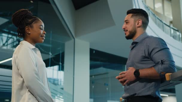 Two multiethnic multiracial colleagues in office talking diverse entrepreneurs African American woman businesswoman and Arabian Indian man businessman talk giving high five partnership unity gesture - Filmmaterial, Video