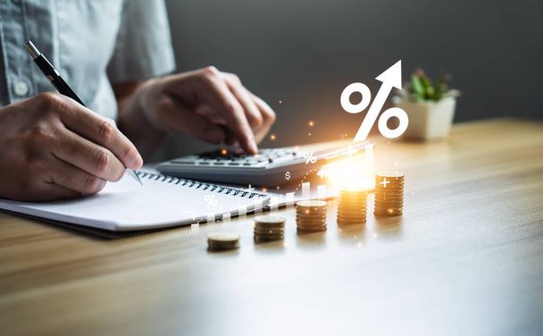interest rates and dividends, investment returns, income, retirement Compensation fund, dividend tax. pile of coins and upward direction percentage symbol. Businessman saving money for investment - Foto, imagen
