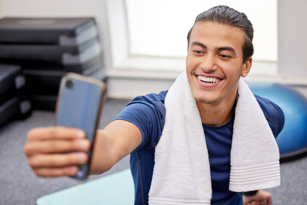 Fitness, man and smile for selfie, social media or profile picture with towel after workout exercise or training at the gym. Happy sporty male vlogger or influencer smiling in happiness for vlog post. - Foto, Imagen