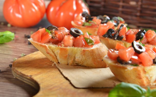 Bruschetta mit Tomaten, Oliven und Basilikum - Foto, Bild