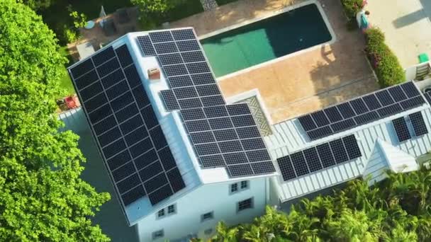 Groot nieuw woonhuis in de VS met dak bedekt met fotovoltaïsche zonnepanelen voor de productie van schone ecologische elektrische energie in de buitenwijken van het platteland. Begrip autonoom huis. - Video