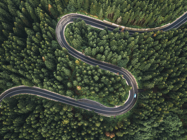 Curved road trough the forest pass in Cheia, Transylvania Romania, aerial view from drone  - Photo, Image