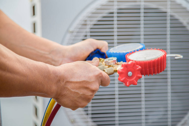 O engenheiro verifica o funcionamento do ar condicionado, verifica a pressão, enche e recarrega o refrigerante de ar condicionado. - Foto, Imagem