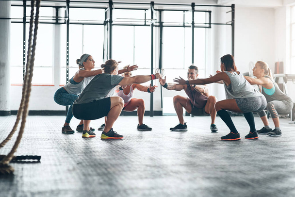 Together we can achieve our fitness goals. a fitness group working out at the gym - Foto, Imagem