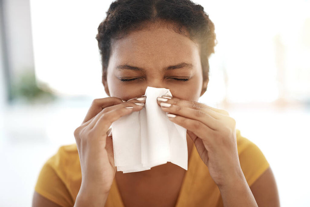 Who let the flu germs in. a young businesswoman blowing her nose in a modern office - Zdjęcie, obraz