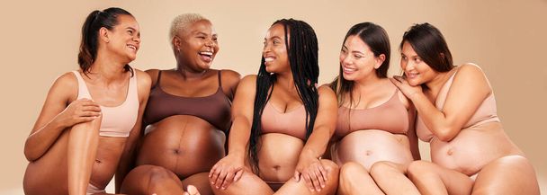 Сміються, зв'язуються і вагітні жінки, що сидять на підлозі в громаді, підтримують різноманітність або здоров'я тіла. Посмішка, щасливі і вагітність друзі в нижній білизні з смішним, комедійним або комічним жартом для охорони здоров'я
. - Фото, зображення