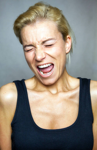 Screaming expression on the young woman's face. - Foto, afbeelding
