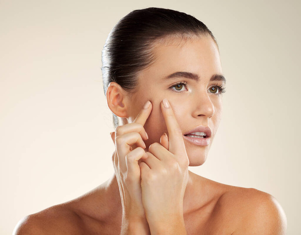 Face, hands and blackhead with a woman checking or examining her skin for acne problems in studio. Facial, fingers and breakout with an attractive young female indoor to squeeze or pop a pimple. - Фото, изображение