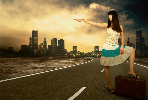 Young woman waiting on the road with her vintage baggage - Photo, image