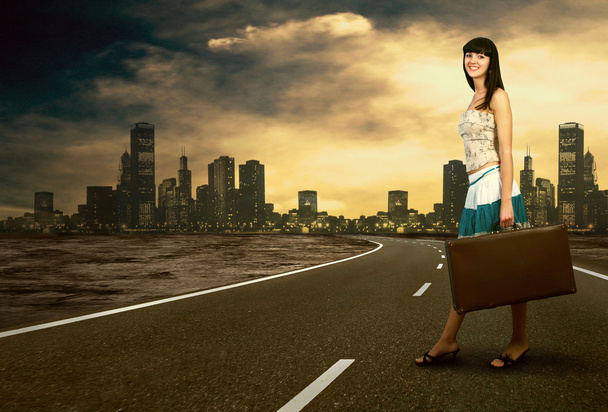 Young woman waiting on the road with her vintage baggage - Foto, Bild