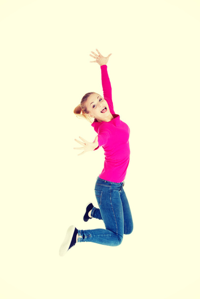 Young caucasian woman is jumping. - Φωτογραφία, εικόνα