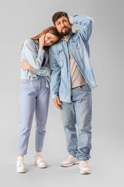 Young couple suffering from loud noise on grey background - Foto, immagini