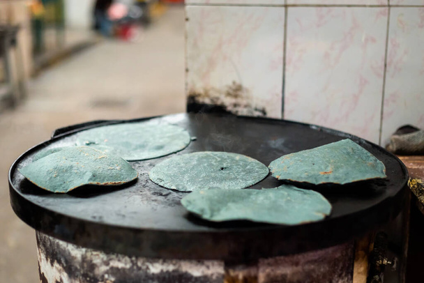 Приготування свіжої блакитної кукурудзяної тортильї на місцевому ринку в Пуеблі. Традиційна мексиканська кухня з свіжих інгредієнтів.. - Фото, зображення
