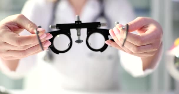 眼科医は、病院のクローズアップ4k映画スローモーションのビジョンを確認するために患者に眼鏡を与えます。視覚概念のための近視と眼鏡の選択の診断 - 映像、動画