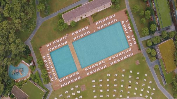 Luchtdrone zicht op het hotelterrein. Bovenaanzicht. Zwembad, palmbomen, ligstoelen. Vakantie in het resort. Hoge kwaliteit foto - Foto, afbeelding