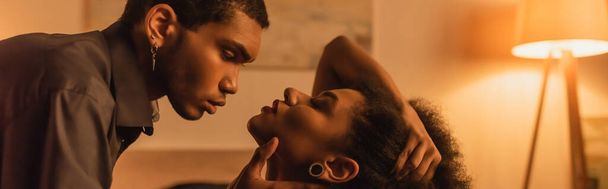 side view of young african american man touching face of seductive girlfriend, banner - Foto, Imagen