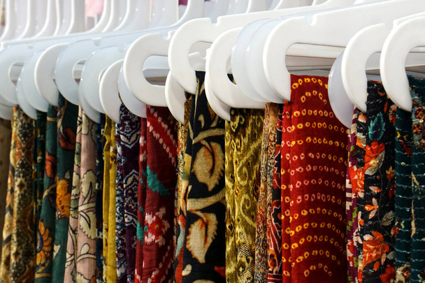 View of Indian woman traditional dress sarees in display, on hangers in a shop                                             - Foto, Imagen
