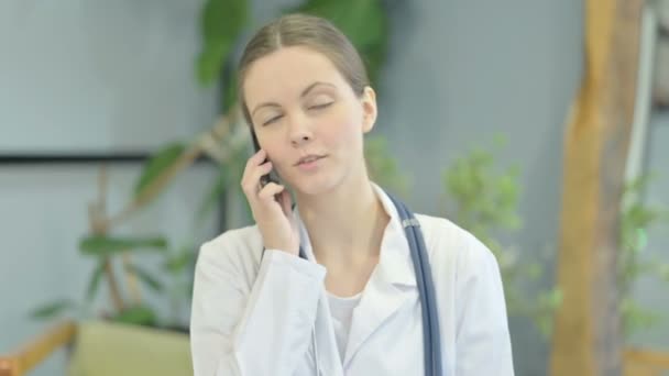 Portrait of Young Female Doctor Talking on Phone in Clinic - Metraje, vídeo