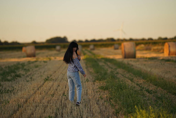 A single mother wanders lost through a mowed field, human loneliness, depression and depression, psychological assistance to women victims of violence, domestic violence against a woman - Foto, afbeelding