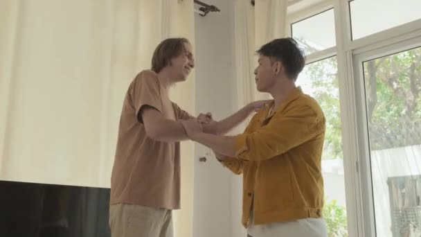 Two best mates shaking hands and embracing when gathering together indoors - Materiał filmowy, wideo
