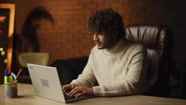 Irritated curly man beating table with his fist while working with laptop. Freelancer expressing negative emotions in home office. Work problems, bad day concept. High quality 4k footage - Séquence, vidéo