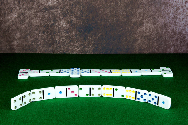 Game of dominoes in progress on a felt table top - Valokuva, kuva