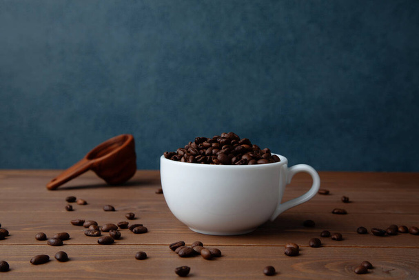 roasted coffee beans in coffee cup closeup on table - Φωτογραφία, εικόνα