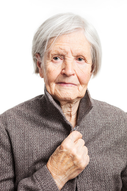 Portrait d'une femme âgée regardant la caméra. Sur fond blanc
. - Photo, image