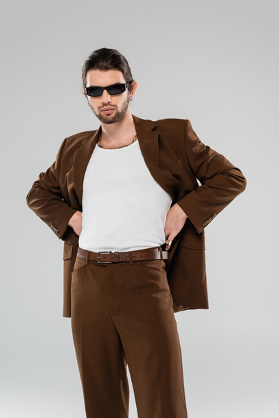 Stylish young man in suit and sunglasses isolated on grey  - Valokuva, kuva