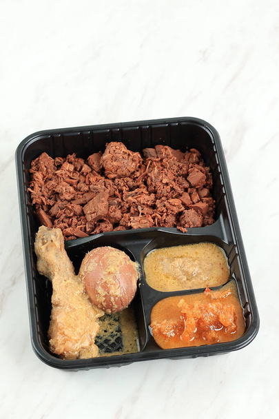 Gudeg Komplit with Chicken Opor and Egg, Served on Plastic Packaging. Concept Food on the Go. Gudeg is Traditional Indonesian Food from Yogyakarta - Foto, immagini